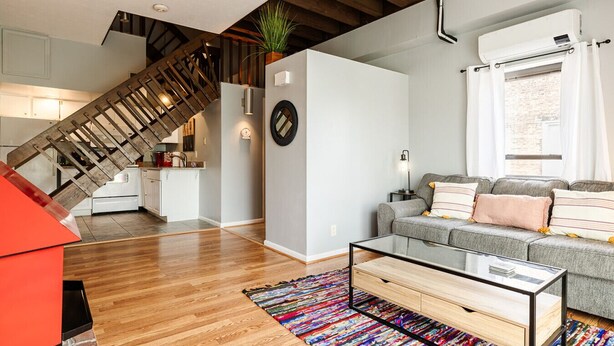 A modern living space with a staircase, kitchen, and seating area. - Mt. Adams 1BR Great Location! Steps from Monastery (Cincinnati)