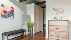 A modern living room with a bench, a cabinet, and a colorful abstract painting. - Mt. Adams 1BR Great Location! Steps from Monastery (Cincinnati)