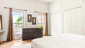 Ein Schlafzimmer mit einem großen Bett, einem Schminktisch und einem Fenster mit Vorhängen.