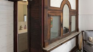 Una habitación con un gran armario de madera, un espejo y una puerta que da a un baño.