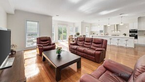 Un salon spacieux avec un canapé en cuir, une table basse et un téléviseur.