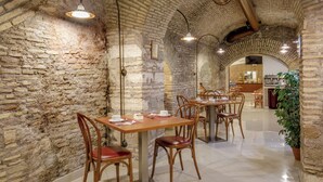 Um restaurante com paredes de tijolo, mesas e cadeiras de madeira.