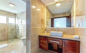 A modern bathroom with a glass shower enclosure, a white sink, and wooden cabinetry. - Snrvittinivillas Mng Spacius and Best Loc in Casa de Campo Resorts Gr8 Villa (La Romana)