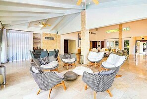A spacious living area with modern furniture, a high ceiling, and a view of the beach. - Snrvittinivillas Mng Spacius and Best Loc in Casa de Campo Resorts Gr8 Villa (La Romana)