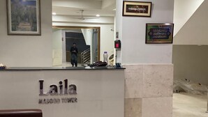 Un comptoir d’accueil avec une pancarte indiquant : « Tour Laila Masood ».