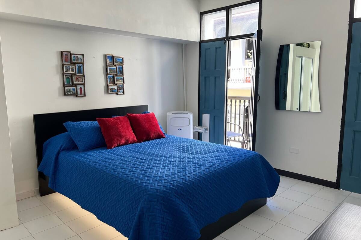 A bedroom with a bed, a radiator, and a balcony door.