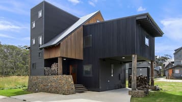 Een modern huis met twee verdiepingen, een stenen fundering, een schuin dak en een ruime garage.