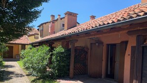 A courtyard with a tiled roof, a brick pathway, and a small garden area. - Apartment In Residence In Porto Levante Ro (Porto Viro)