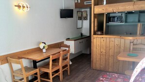 A compact kitchen with wooden cabinets, a microwave, and a sink.