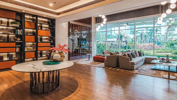 A modern living room with a large bookshelf, a round coffee table, and a sofa facing large windows. - EBONY by Kozystay (Jakarta)