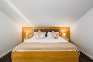 A single bed with a wooden headboard, two bedside lamps, and a neutral-toned bedspread. - Sunset Suite Premium Apartment (Porec)
