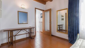 A room with a wooden bench, a large mirror, and a door leading to another room. - SUITE ARENA IN CENTRO CITTA' (Verona)