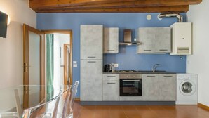 A compact kitchen with a built-in oven, a washing machine, and a sink. - SUITE ARENA IN CENTRO CITTA' (Verona)