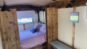 Un dormitorio acogedor con cama, un banco y una ventana.
