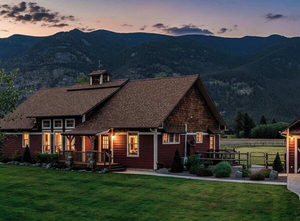 A two-story house with a sloped roof, a front porch, and a well-maintained lawn.