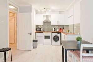 Departamento, 1 cama Queen size y sofá cama | Cocina privada | Refrigerador, microondas, horno y parrilla de estufa 