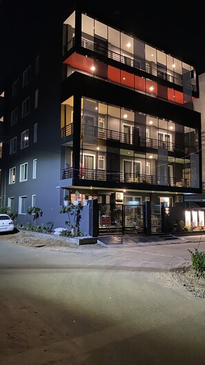 A modern two-story building with balconies, large windows, and a gated entrance. - BK Studio (Gurugram)
