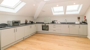 A modern kitchen with skylights, a microwave, toaster, oven, and a sink. - Sardis Chapel 1 (Bodorgan)