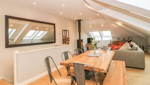 A modern loft apartment with a dining area, a sofa, and a large mirror. - Sardis Chapel 1 (Bodorgan)