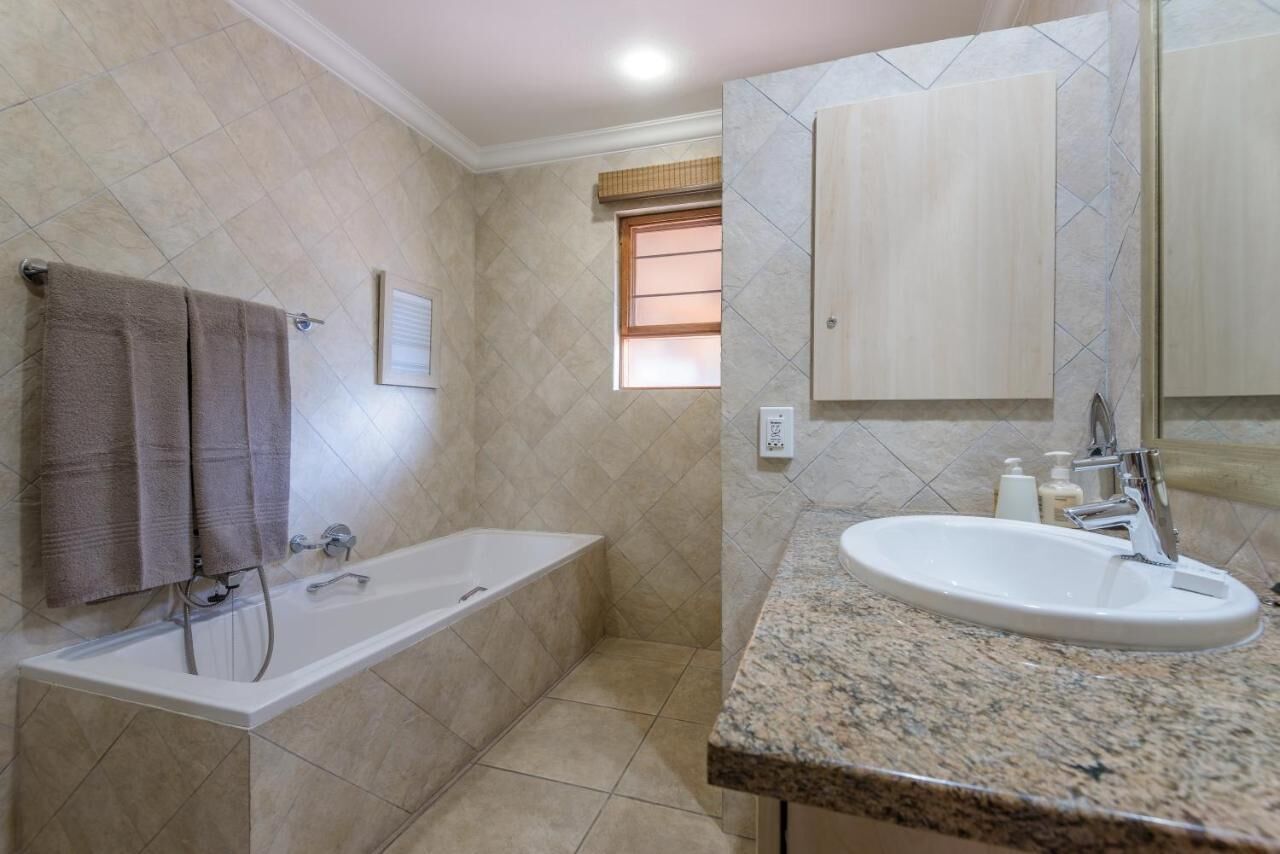 Un baño con bañera, lavamanos y ventana.