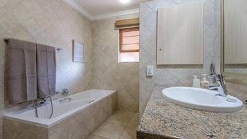 Un baño con bañera, lavamanos y ventana.