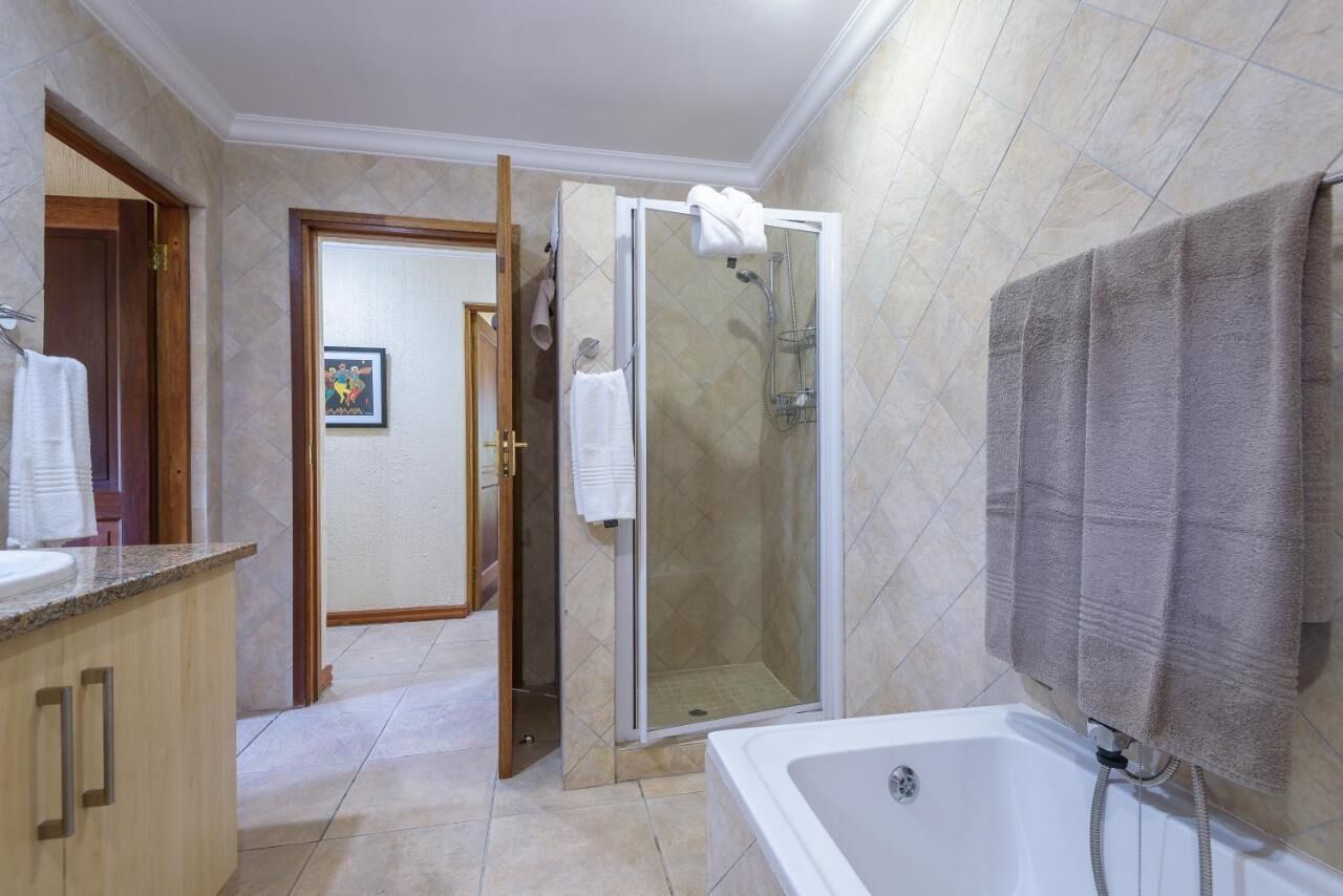 A bathroom with a shower, a bathtub, and a vanity with a sink.