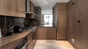 A modern kitchen with wooden cabinets, a stainless steel range, and a built-in oven.