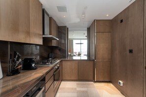 A modern kitchen with wooden cabinets, a stainless steel range, and a built-in oven.