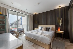 Een moderne hotelkamer met een groot bed, een bureau en uitzicht op de stad.