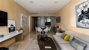 A modern living room with a sofa, coffee table, and artwork on the walls.