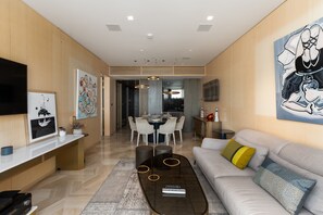 Un salon moderne avec un canapé, une table basse et des œuvres d’art accrochées aux murs.
