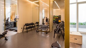 A gym with exercise equipment, a treadmill, and a mirror.