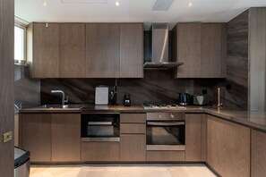 A modern kitchen with wooden cabinets, stainless steel appliances, and a built-in oven.
