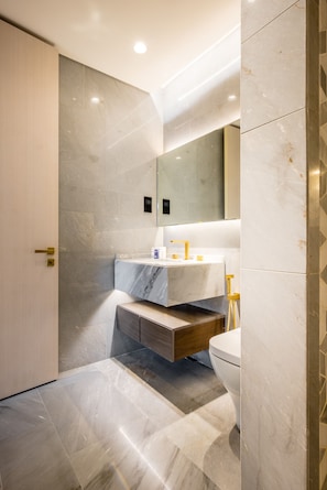 Une salle de bain moderne avec un meuble-lavabo en marbre, un évier et des toilettes.