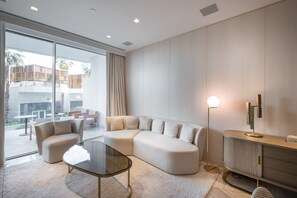 Ein modernes Wohnzimmer mit einer Eckcouch, einem Glastisch und einer Stehlampe.