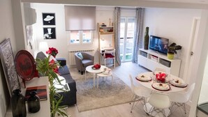 Un salon moderne avec un canapé, une table basse et un coin repas aménagé pour prendre un repas.