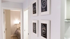 Un couloir orné de tableaux encadrés représentant des symboles liés au yoga et à la santé.