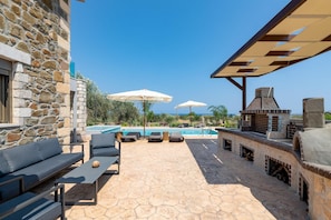 Un bâtiment en pierre doté d’une piscine, d’un espace extérieur aménagé et d’un coin barbecue.