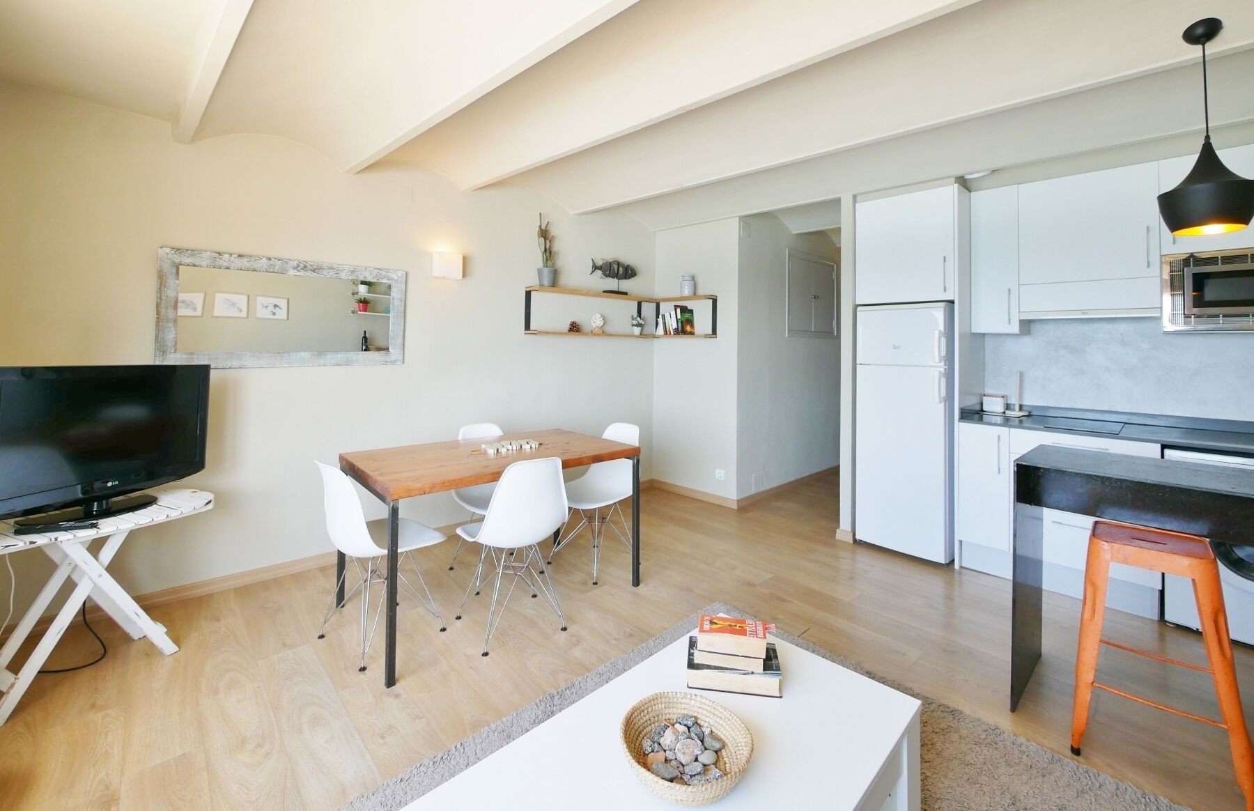A modern kitchen with white cabinets, a black countertop, and a microwave.