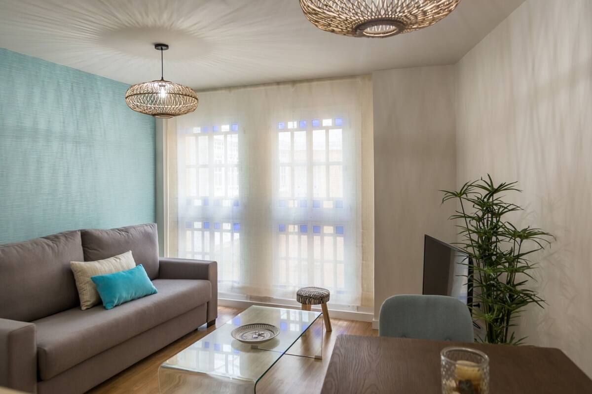 Un salon avec un canapé, une table basse, un fauteuil et une plante.