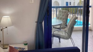 A balcony with a view of a pool and buildings. -  Pool view apartment, walk to the beach and harbour (Paphos)