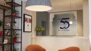 A modern interior with a large window displaying 'The 55 By Le Mirage'.