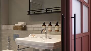 Une salle de bain avec un lavabo blanc, un miroir et un porte-serviettes.