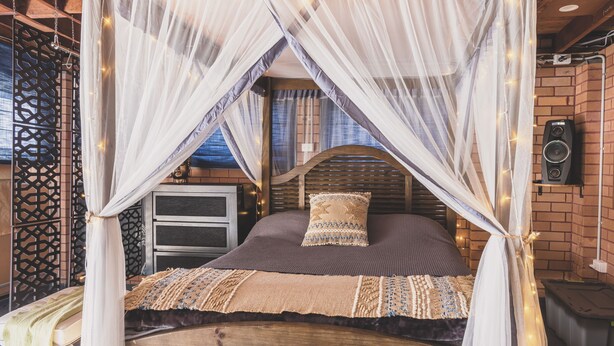 A bed with a canopy, a wooden headboard, and a patterned bedspread. - Vibin' Fun House 400meters (5 min walk) to D'Albora Marinas.
Outdoor Spa
 (Nelson Bay)