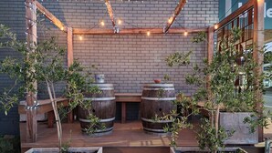An outdoor seating area with wooden tables and chairs, surrounded by planters and barrels. - Vibin' Fun House 400meters (5 min walk) to D'Albora Marinas.
Outdoor Spa
 (Nelson Bay)