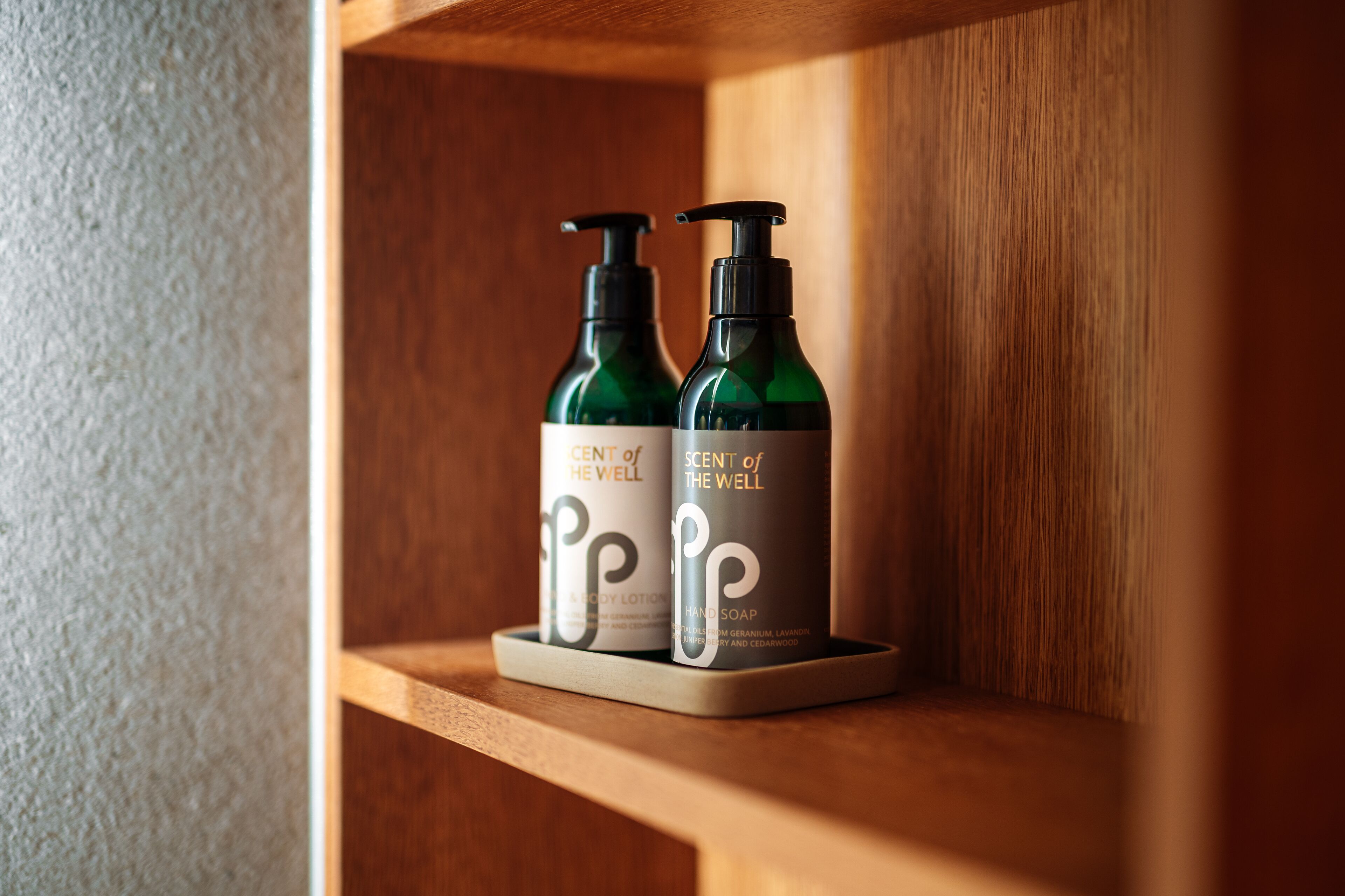 Dos botellas de jabón de manos 'Scent of the Well' sobre una repisa de madera.