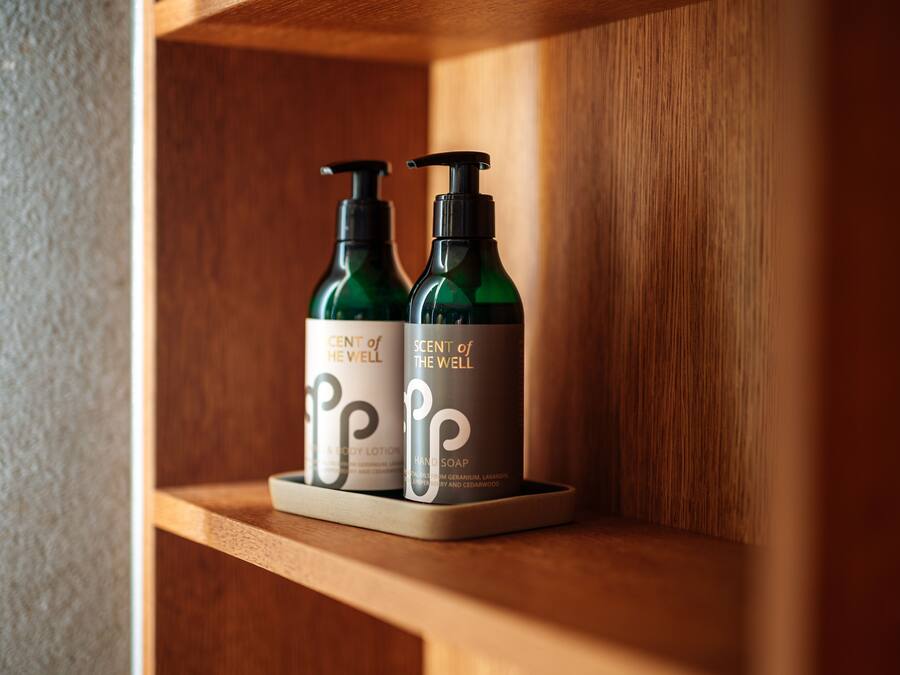 Dos botellas de jabón de manos 'Scent of the Well' sobre una repisa de madera.