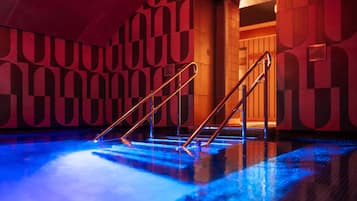 A swimming pool with a geometric wall pattern and a staircase leading to an upper level.