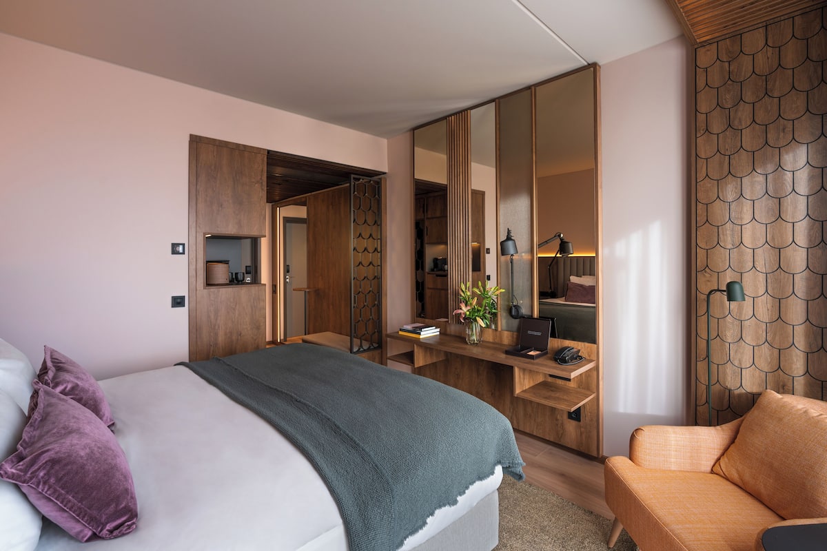 A modern bedroom with a bed, a desk, and a chair.