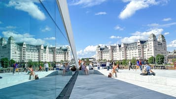 A modern glass bridge with a clear view of historic buildings in the background.